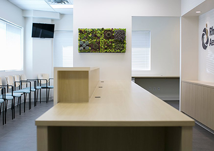 White glossy desk at reception area with live plant art